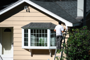 a person painting their home’s exterior